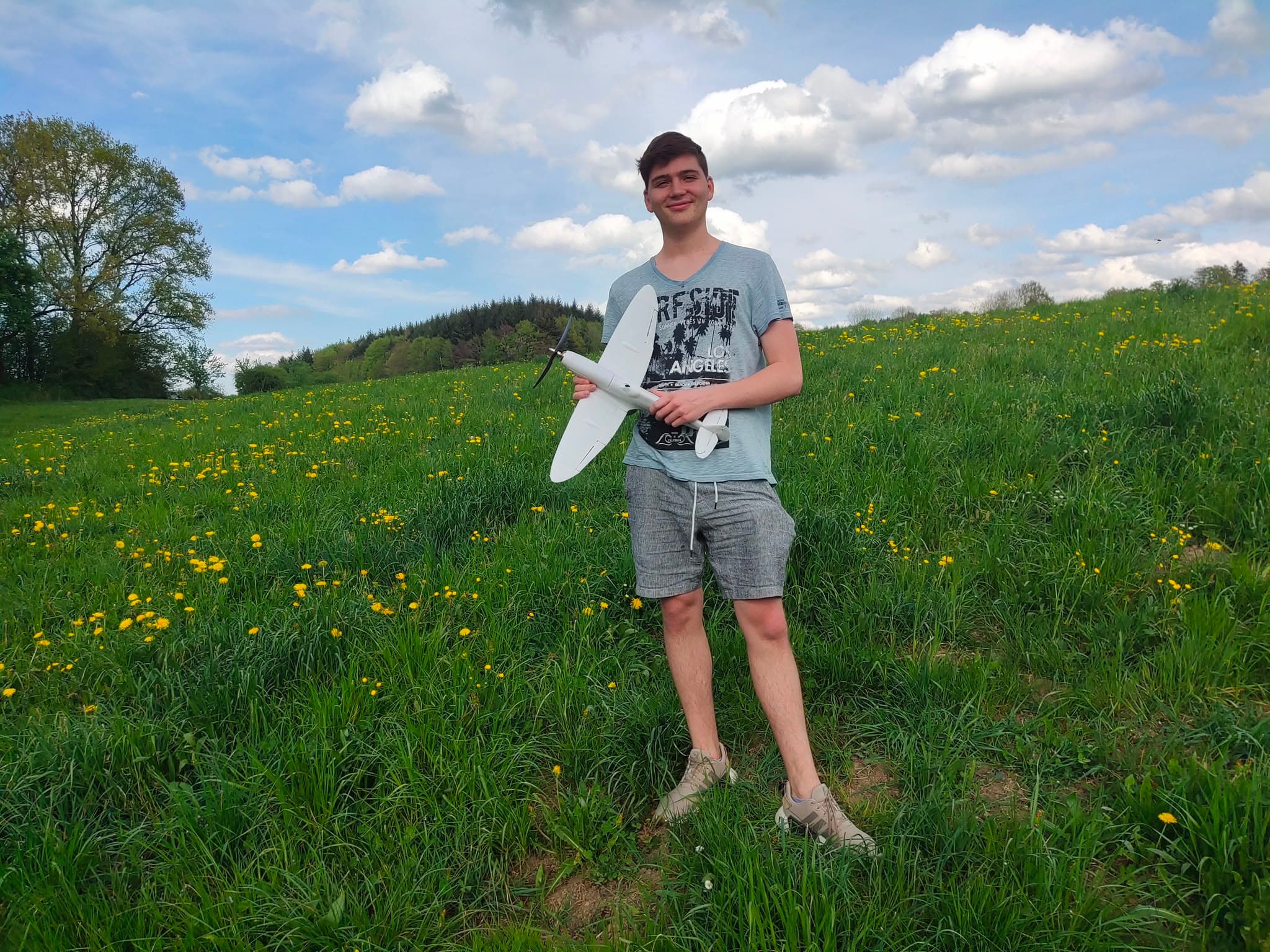 Holding the unpainted 3D-printed Spitfire in a flowering meadow shortly before the hand-launched maiden flight