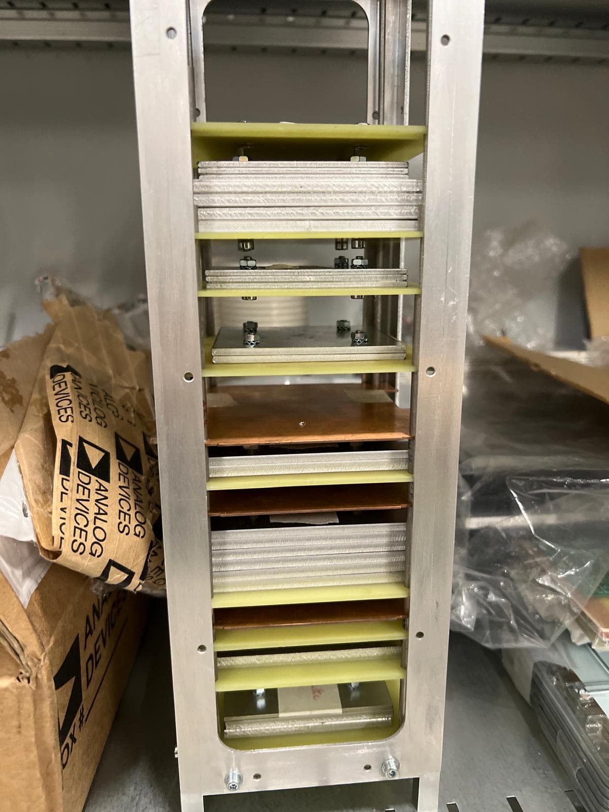 The assembled CHESS mass model — an aluminium frame holding a stack of metal dummy plates separated by yellow G10 spacers